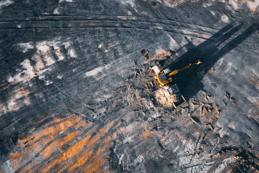 Aerial view of an excavator on a large earthworks site for cut and fill quantities