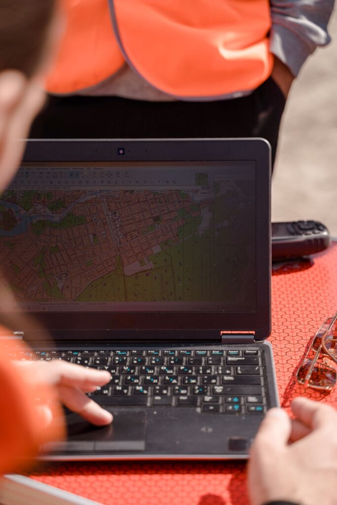 Field surveyor using a laptop for mapping, spot levels and cross-sections